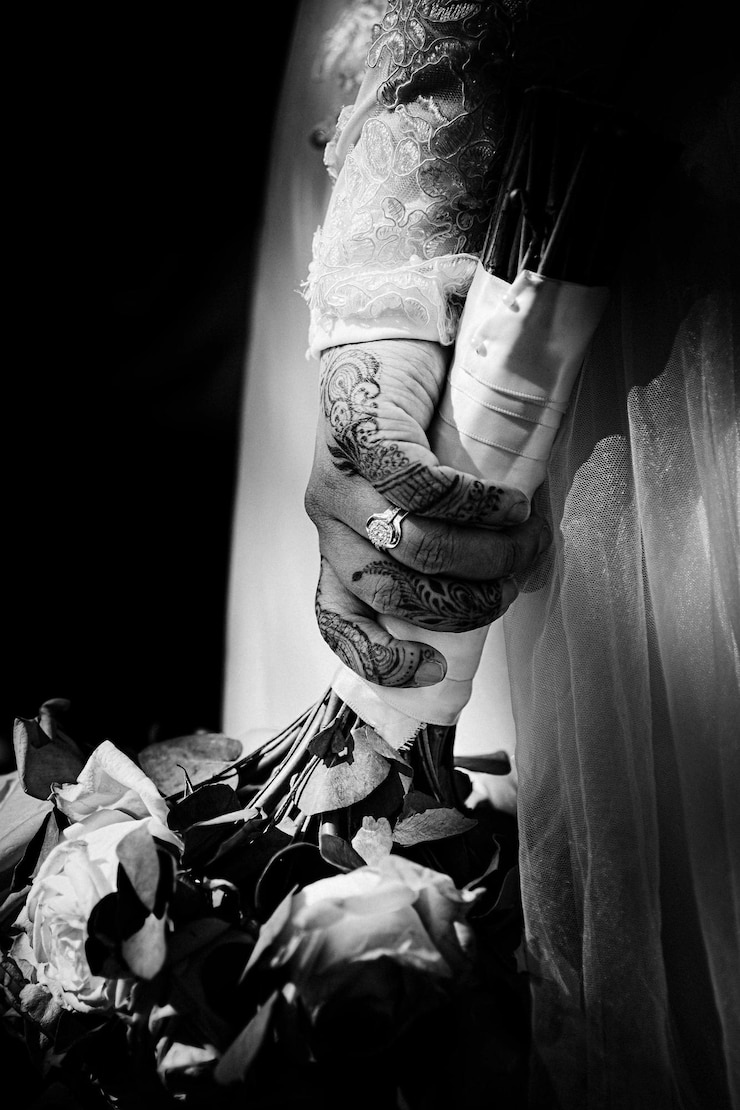 Photo la mariée avec des mains dessinées au henné tenant des fleurs