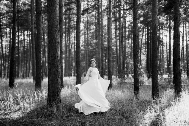 La mariée marchant dans une forêt de pins par un beau jour