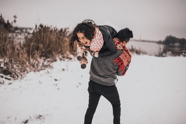 Mariée et le marié amoureux couple dans des mitaines écharpe tricotée en hiver et flocons de neige