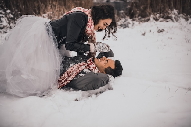 Mariée et le marié amoureux couple dans des mitaines écharpe tricotée en hiver et flocons de neige