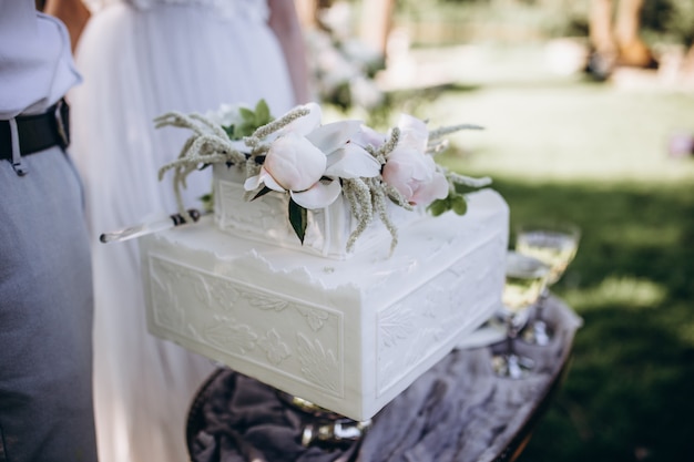 Une mariée et un marié coupent leur beau gâteau de mariage. nicel light. concept de mariage