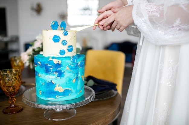 Une mariée et un marié coupent leur gâteau de mariage