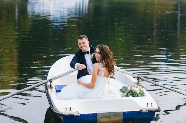 La mariée et le marié dans une barque sur le lac