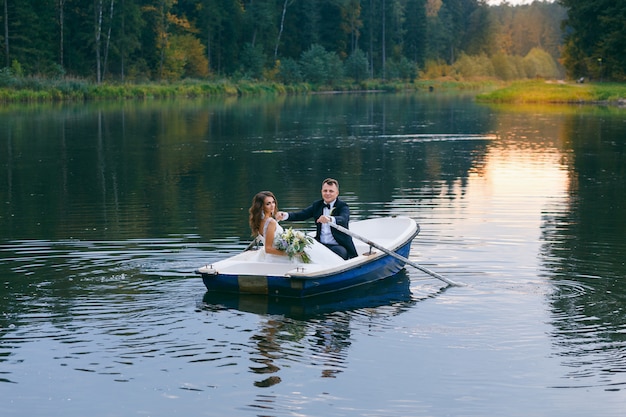 La mariée et le marié dans une barque sur le lac