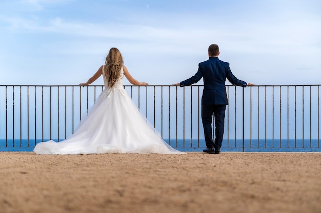 Une mariée et un marié donnent sur l'océan à la côte de San Diego