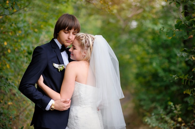 Mariée et le marié élégant posant ensemble à l'extérieur le jour du mariage