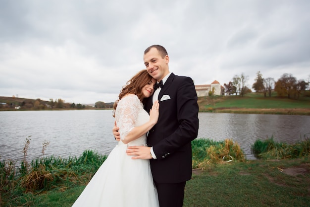 Mariée et le marié à l'extérieur du parc sous l'arc