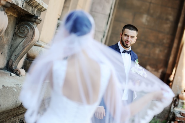 Photo la mariée et le marié sur le fond d'un immeuble ancien