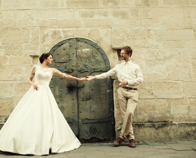 Mariée et marié heureux romantiques de luxe célébrant le mariage à la surface de la vieille ville ensoleillée