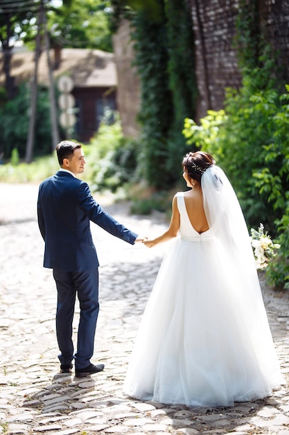 La mariée et le marié marchent ensemble dans le parc Jolie mariée et marié élégant Jour du mariage Mariage