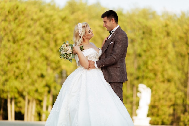 La mariée et le marié marchent ensemble dans le parc.