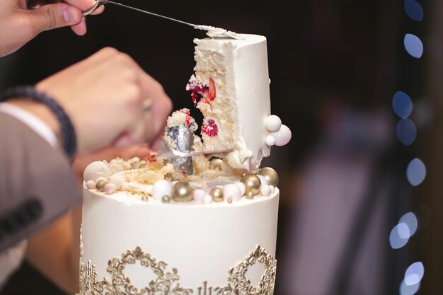 La mariée et le marié ont coupé un magnifique gâteau de mariage lors d'un banquet