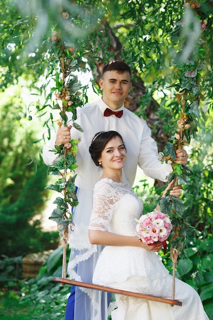 Mariée et marié posant dans un jardin