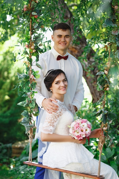 Mariée et marié posant dans un jardin