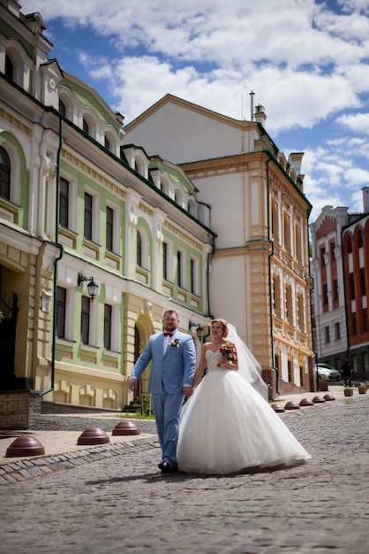 la mariée et le marié posant pour la caméra dans les rues de la vieille ville.