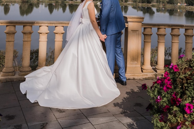 Mariée et marié près de la balustrade sur le remblai