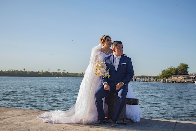 Mariée et marié sur un quai au bord de l'eau