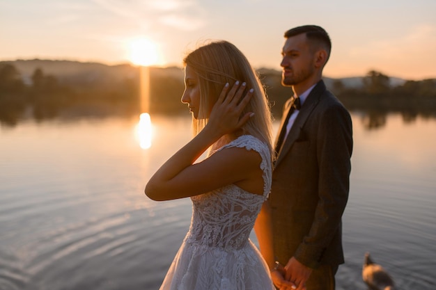 La mariée et le marié rencontrent ensemble le coucher du soleil