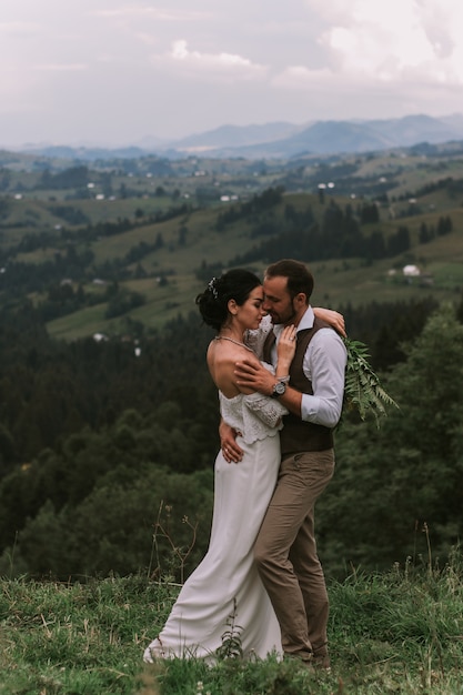 Mariée et marié s'embrassant dans les montagnes