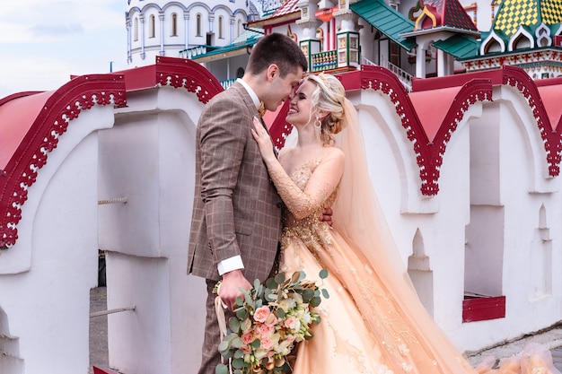 La Mariée Et Le Marié S'embrassent Dans La Rue Dans Le Vieux Kremlin. Jour De Mariage