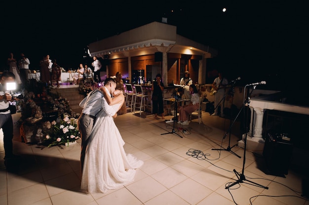 La mariée et le marié s'embrassent et dansent sur la piste de danse.