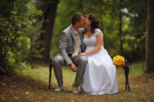 Photo mariée et marié se promènent dans le parc en été