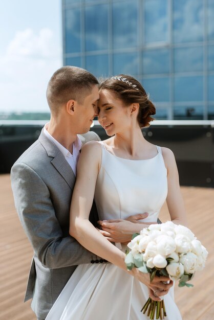 La mariée et le marié se rencontrent sur le toit d'un gratte-ciel.