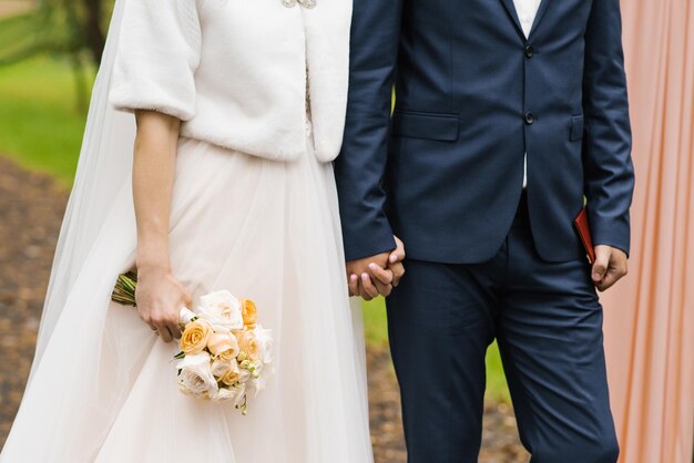 La mariée et le marié se tiennent la main la Saint-Valentin en couple