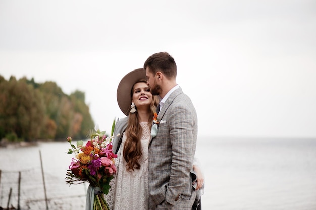 La mariée et le marié se tiennent sur la plage pendant la cérémonie de mariage