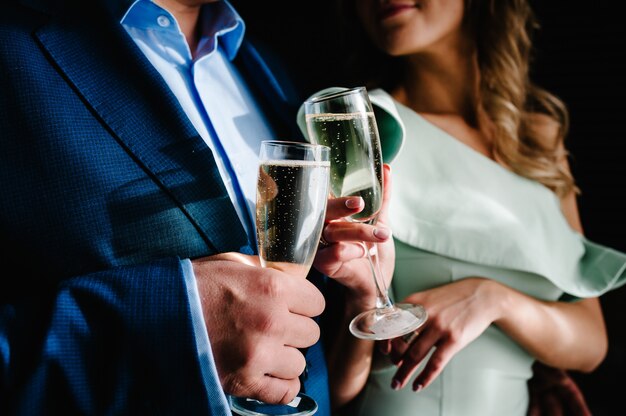 La mariée et le marié tient une coupe de champagne et se tiennent dans la chambre