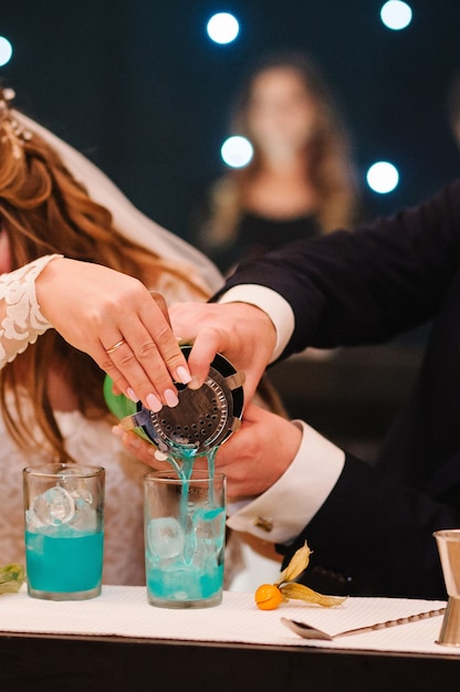 La mariée et le marié versent un cocktail