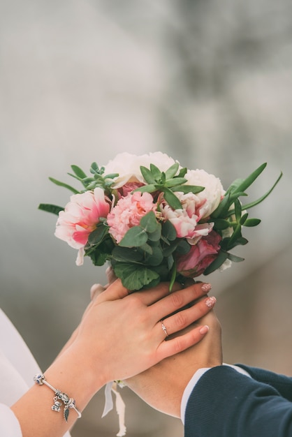 Mariée et mariée, main dans la main avec bouquet de mariée fleur