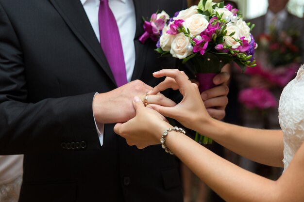 La mariée met un anneau au doigt du marié