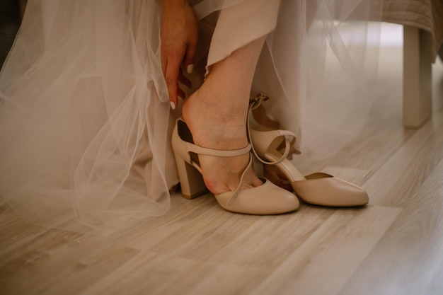 la mariée met des chaussures en cuir verni marron avant la cérémonie de mariage. fille met des chaussures marron