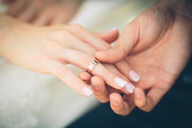 Mariée mettant une bague au doigt du marié