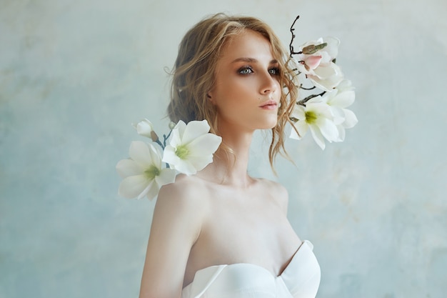 Mariée parfaite avec des bijoux, un portrait d'une fille dans une longue robe blanche.