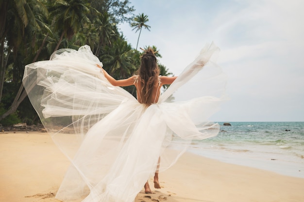 Mariée portant une belle robe de mariée sur la plage tropicale