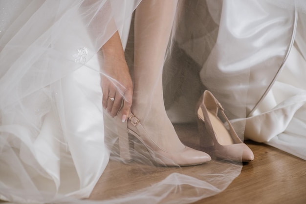 Une mariée portant des chaussures le jour du mariage matin close up