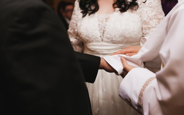 Une mariée porte une robe de mariée et est tenue par son fiancé.