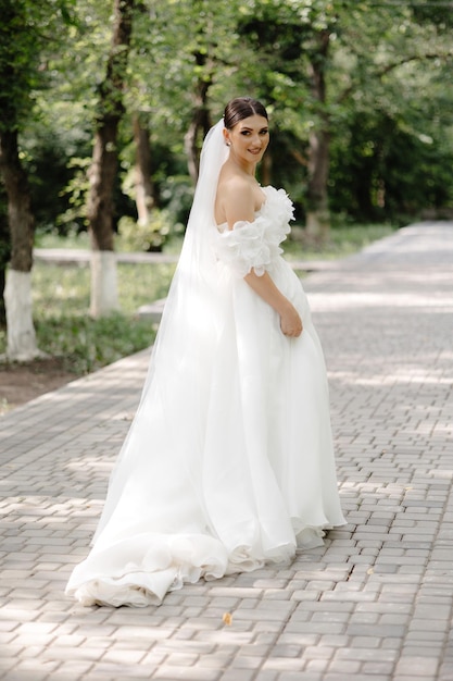 une mariée pose pour une photo dans un parc