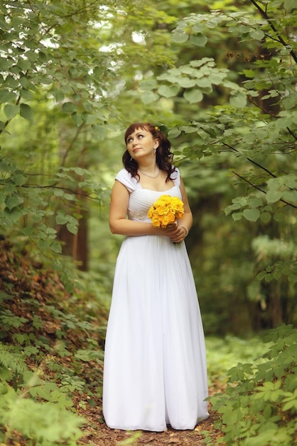 mariée une promenade dans le parc dans les bois