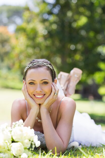 Mariée reposante sur l&#39;herbe dans le parc