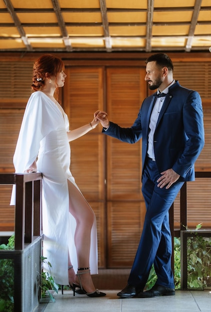 Mariée en robe blanche avec un bouquet et le marié en costume bleu