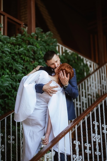 Mariée en robe blanche avec un bouquet et le marié en costume bleu