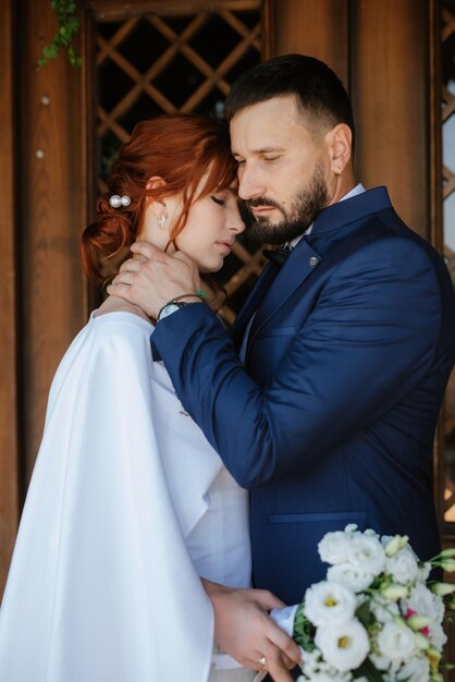 Mariée en robe blanche avec un bouquet et le marié en costume bleu