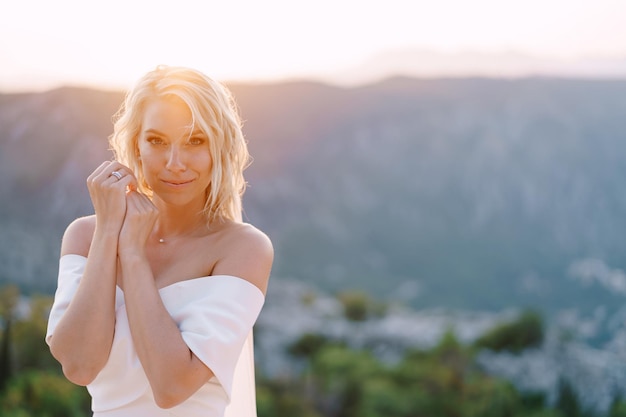 Mariée en robe blanche sur fond de portrait de montagnes