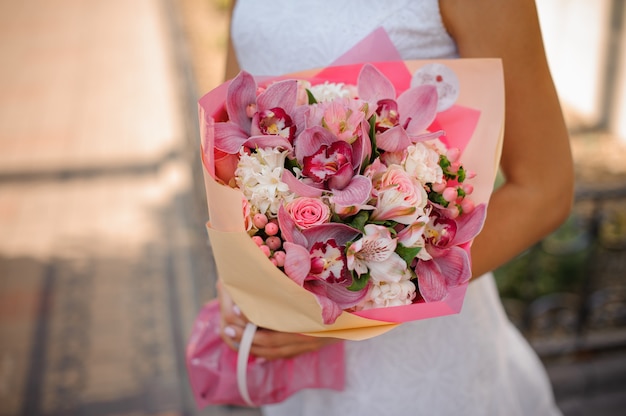 Mariée en robe blanche tenant un beau bouquet de fleurs