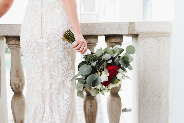 Mariée en robe blanche tenant le bouquet de mariage