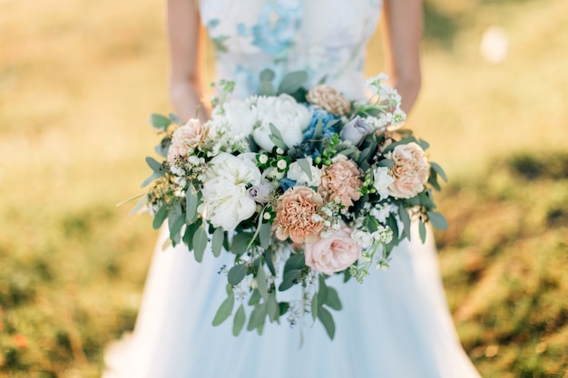 Mariée en robe blanche tenant le bouquet