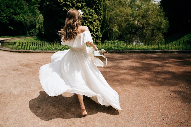 Mariée En Robe De Mariée Blanche Fuyant La Cérémonie De Mariage Tenant Ses Chaussures Dans Ses Mains